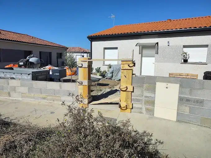 Chantier maisons individuelles : construction et aménagements Chantier résidentiel ensoleillé : deux maisons, mur en parpaings, coffrage bois pour pilier, coffret utilitaire (CE OBRA). Matériel de construction.